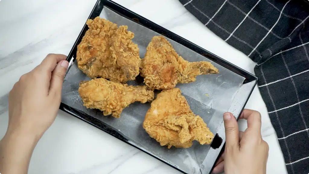 Placing cooked leftover KFC onto a baking tray