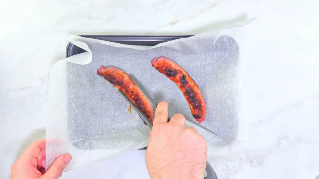 Sausages being placed into a lined tray