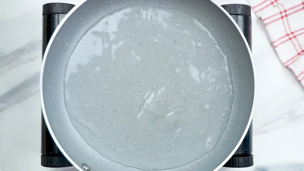 A skillet with half an inch of water in on a hob