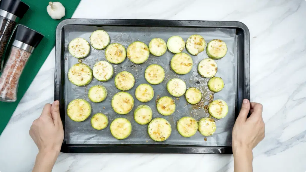Courgette slices spread out on a baking tray