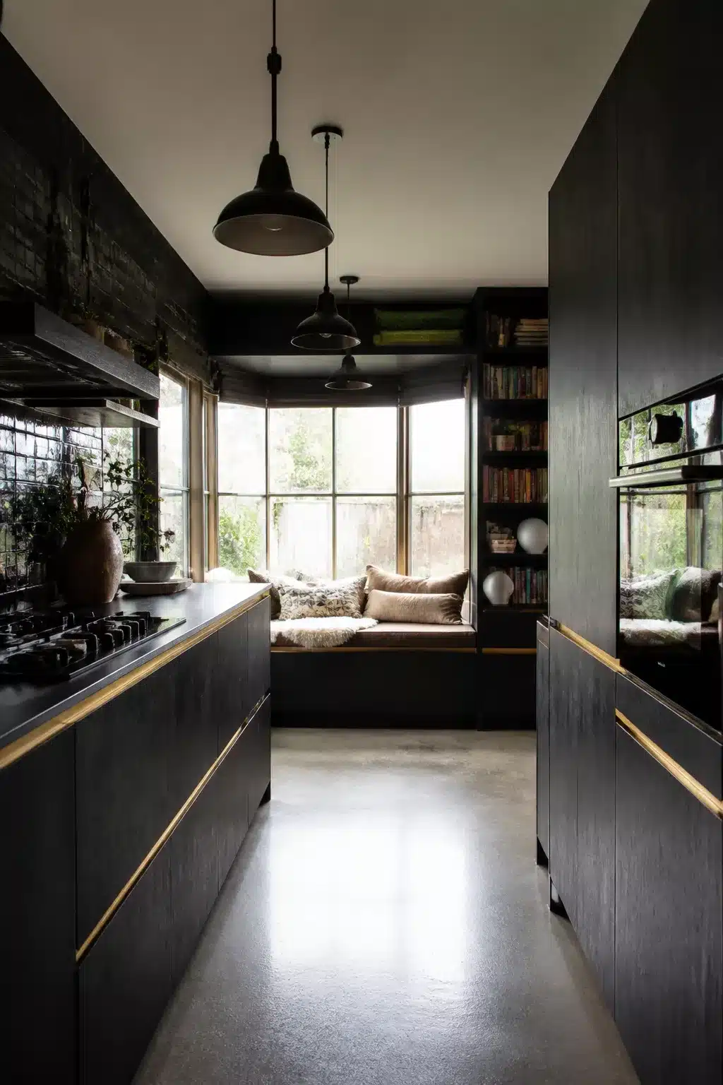 Narrow black galley kitchen with slim brass finger pulls, dark timber cabinets and polished concrete floor — black kitchens with brass handles
