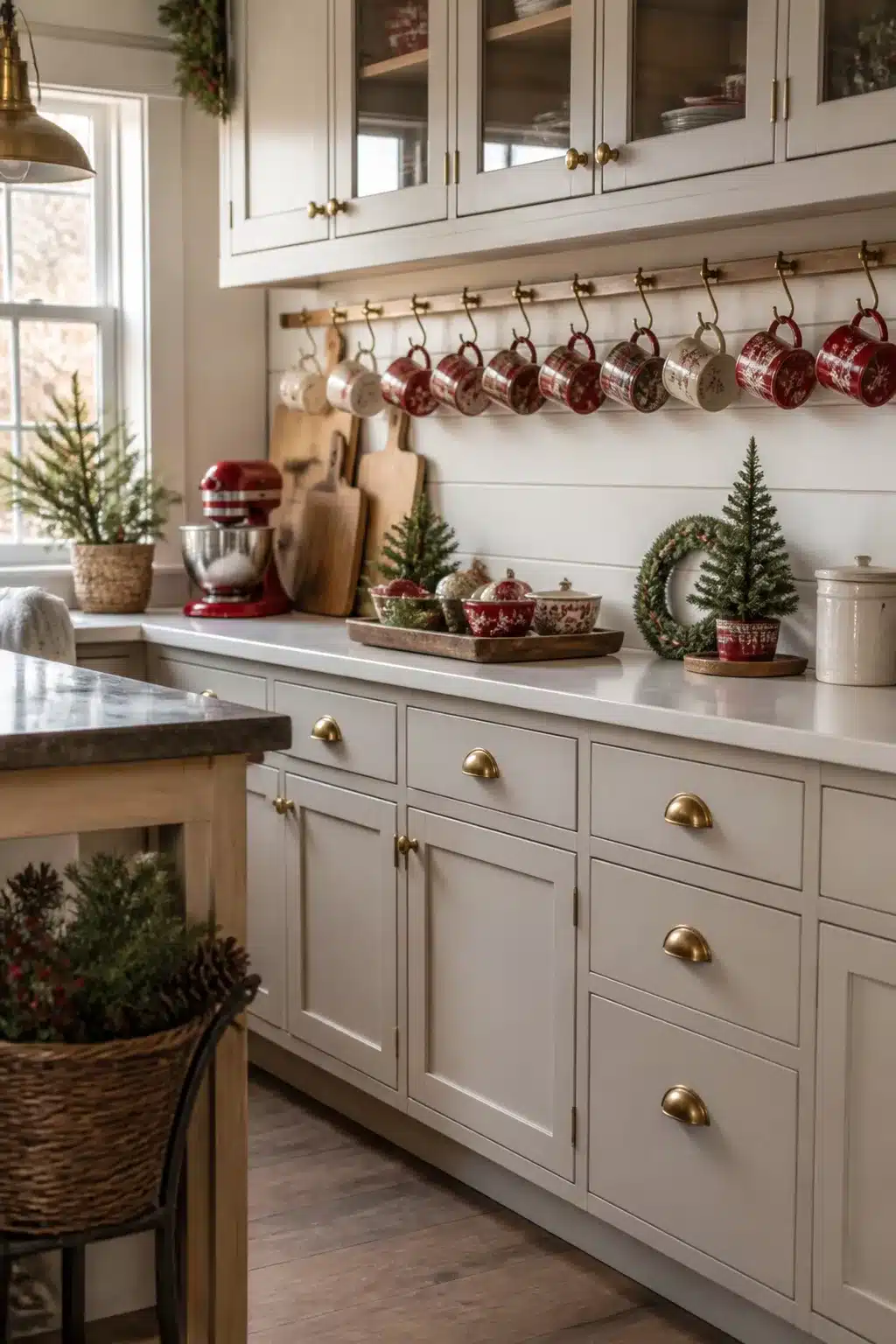 Red transferware mugs on brass rail hooks in a cream shaker cabinet kitchen — Christmas Kitchen Decor idea