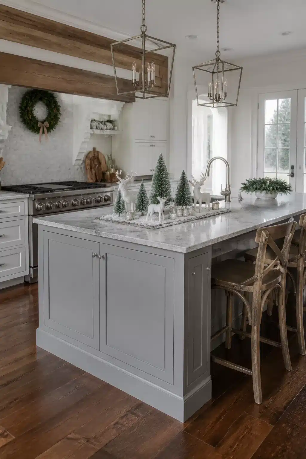 Christmas kitchen island decor with bottle brush trees, white reindeer, and marble countertop in a gray shaker kitchen