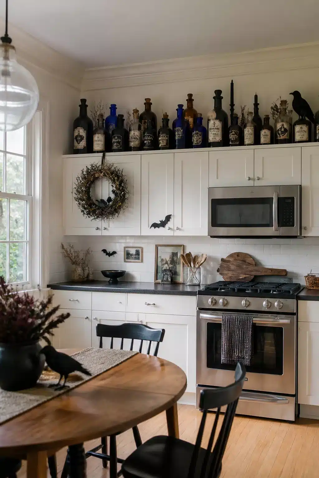 Cobalt and amber apothecary bottles as Halloween decor above kitchen cabinets with crow silhouettes and bat wreath