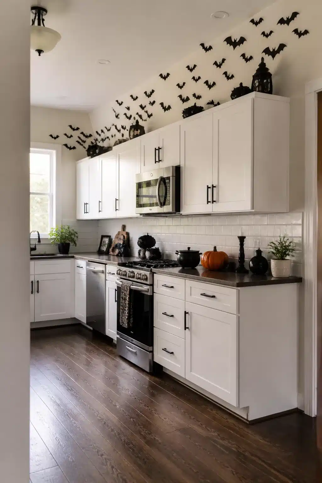 Halloween decor above kitchen cabinets — paper bat swarm spreading across white shaker cabinets and wall