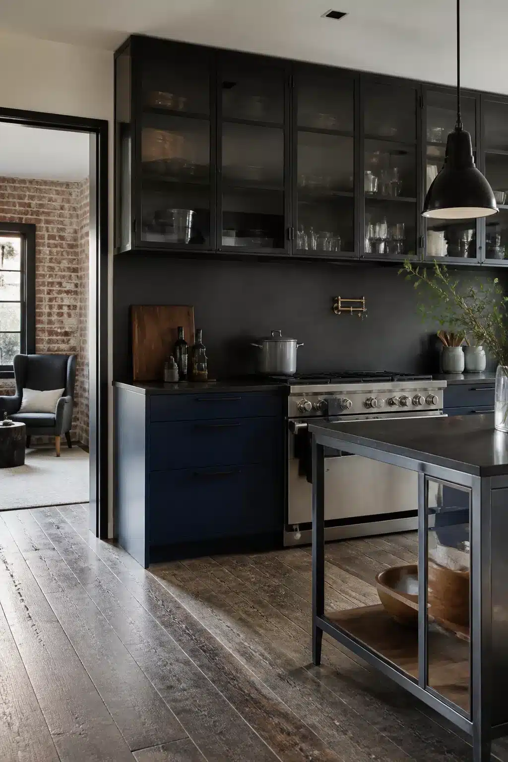 Modern industrial kitchen with smoked glass upper cabinets, navy lowers, brass pot filler, and wide-plank wood floors.