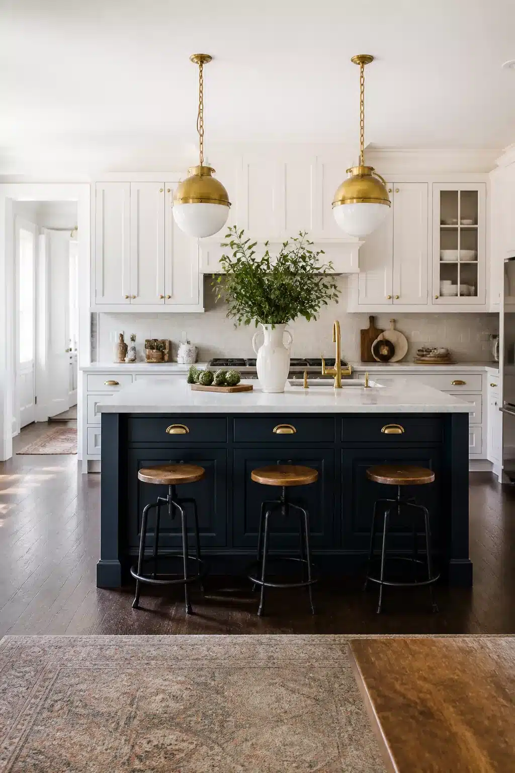 Traditional kitchen remodel idea with deep navy island, white marble countertops, and brass globe pendant lights.