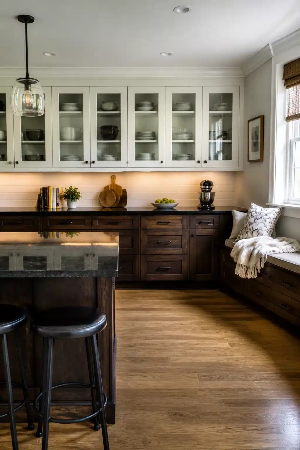 Two tone kitchen cabinet ideas with dark espresso lowers and white glass-front upper cabinets with a window bench