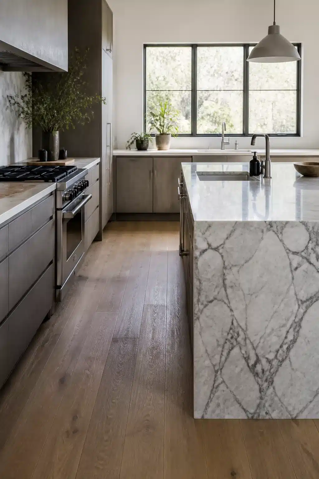 Gray-stained oak wood kitchen cabinets with Arabescato marble countertops and thick waterfall island edge