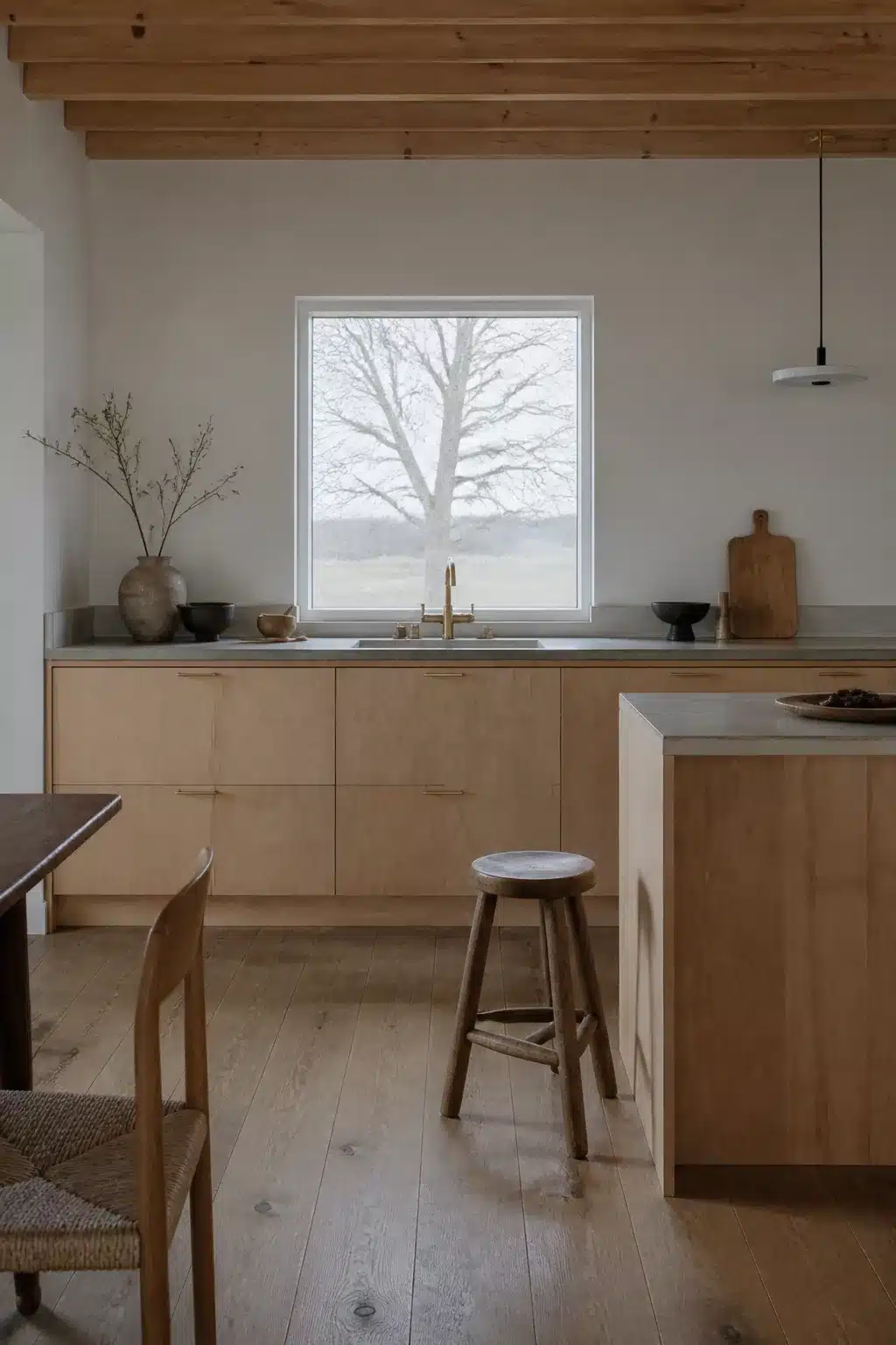 Pale birch wood kitchen ideas with concrete countertops, exposed beams, and a picture window above the sink