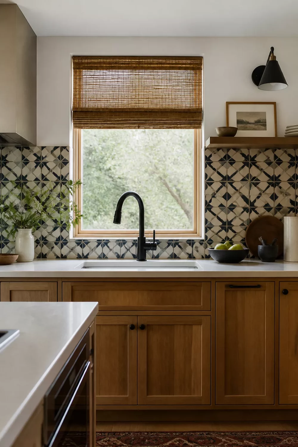 Matte black kitchen faucet at undermount sink with geometric patterned tile backsplash and warm wood cabinets