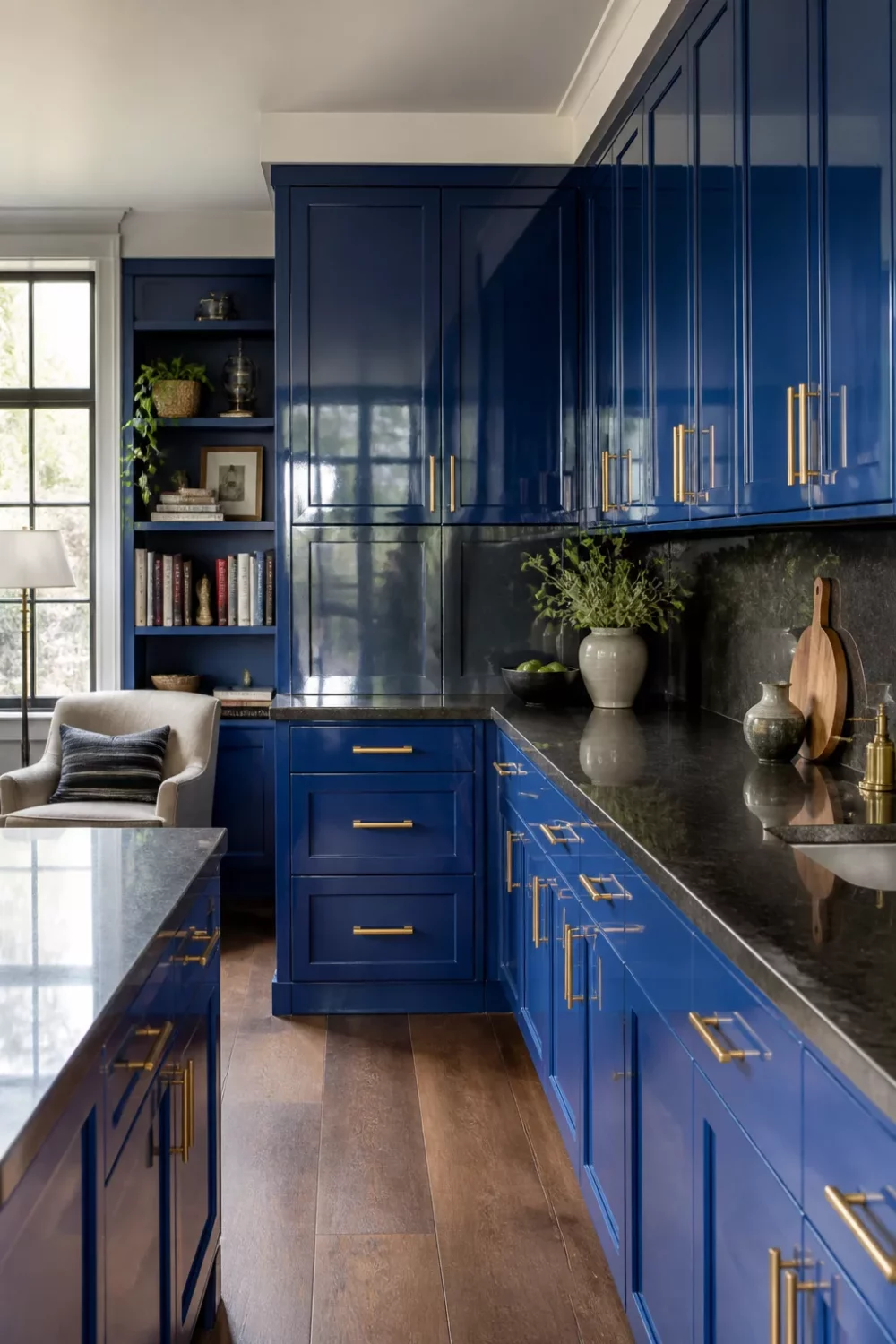 Cobalt blue gloss kitchen cabinets with gold bar hardware and black granite countertops