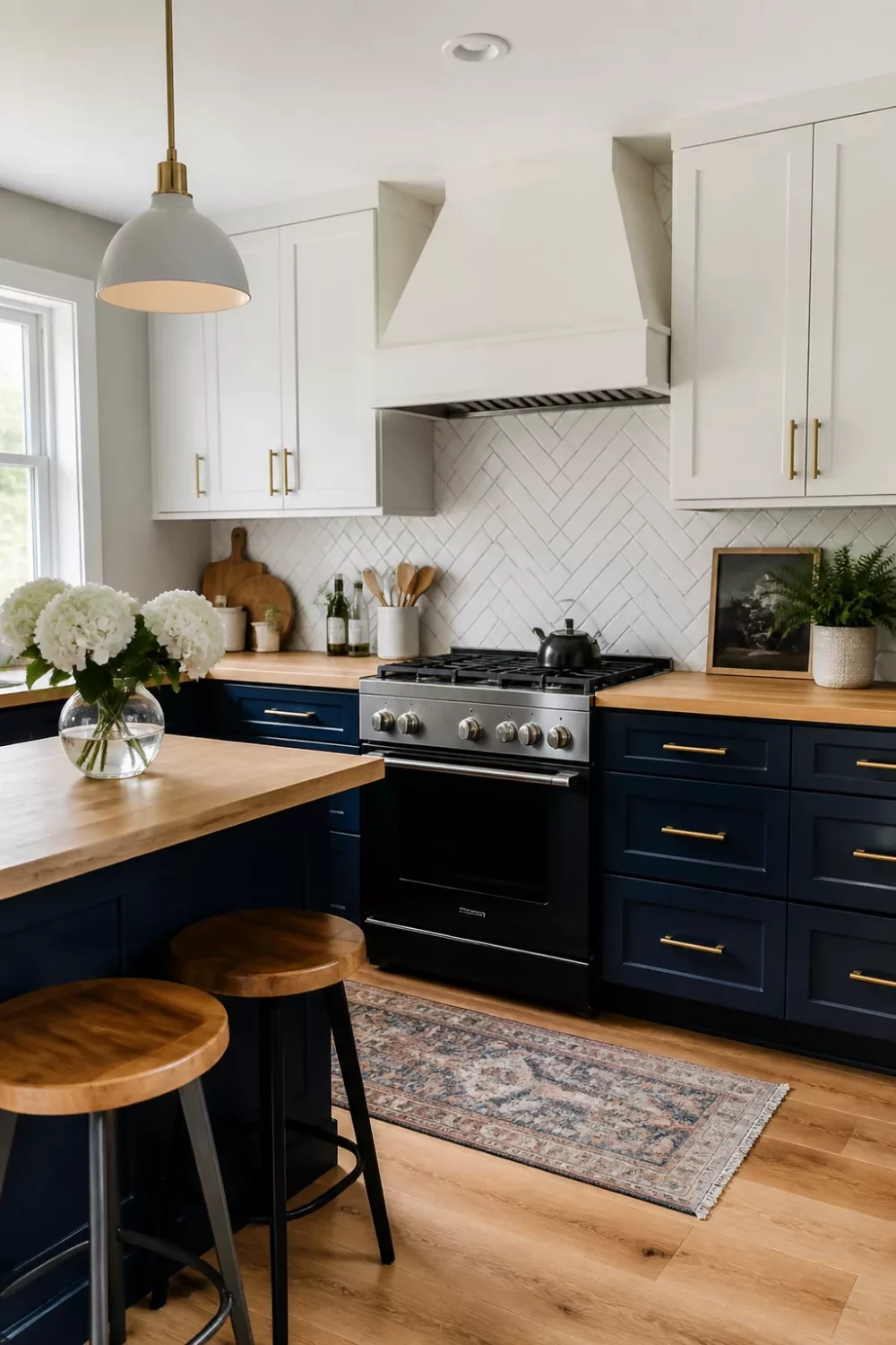 Midnight blue two-tone kitchen with maple wood countertops, herringbone backsplash, and brass hardware — blue kitchens with wood countertops