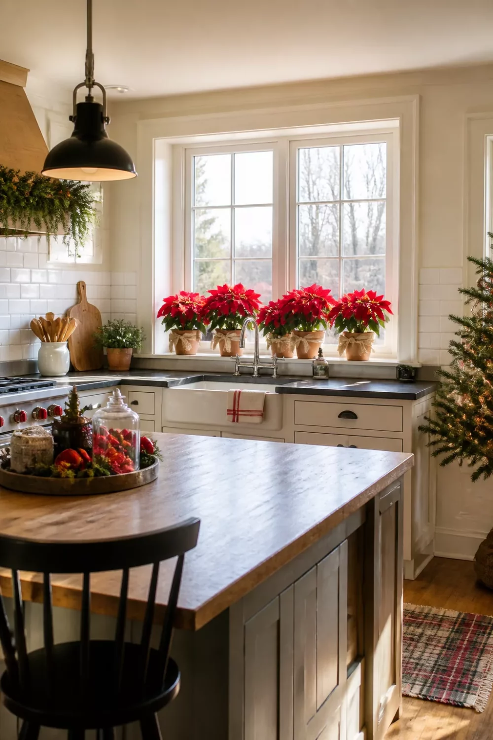 Red poinsettias in terra cotta pots on a farmhouse kitchen windowsill — Christmas kitchen ideas