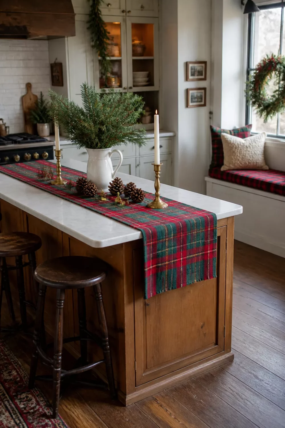 Red tartan runner with brass candlesticks and pine clippings on a kitchen island — Christmas kitchen ideas