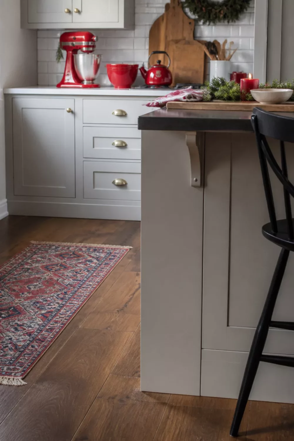 Christmas kitchen ideas with red stand mixer, red kettle, and gray shaker cabinets on dark wood floors