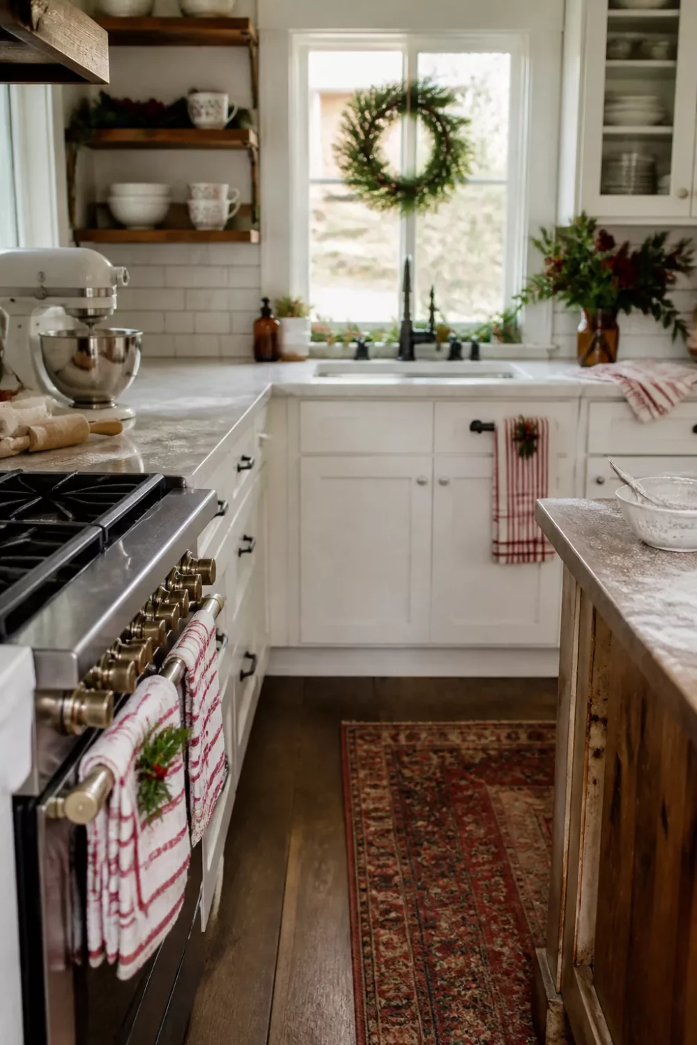 Red and white striped dish towels hung on a stove in a festive Christmas kitchen ideas farmhouse setting
