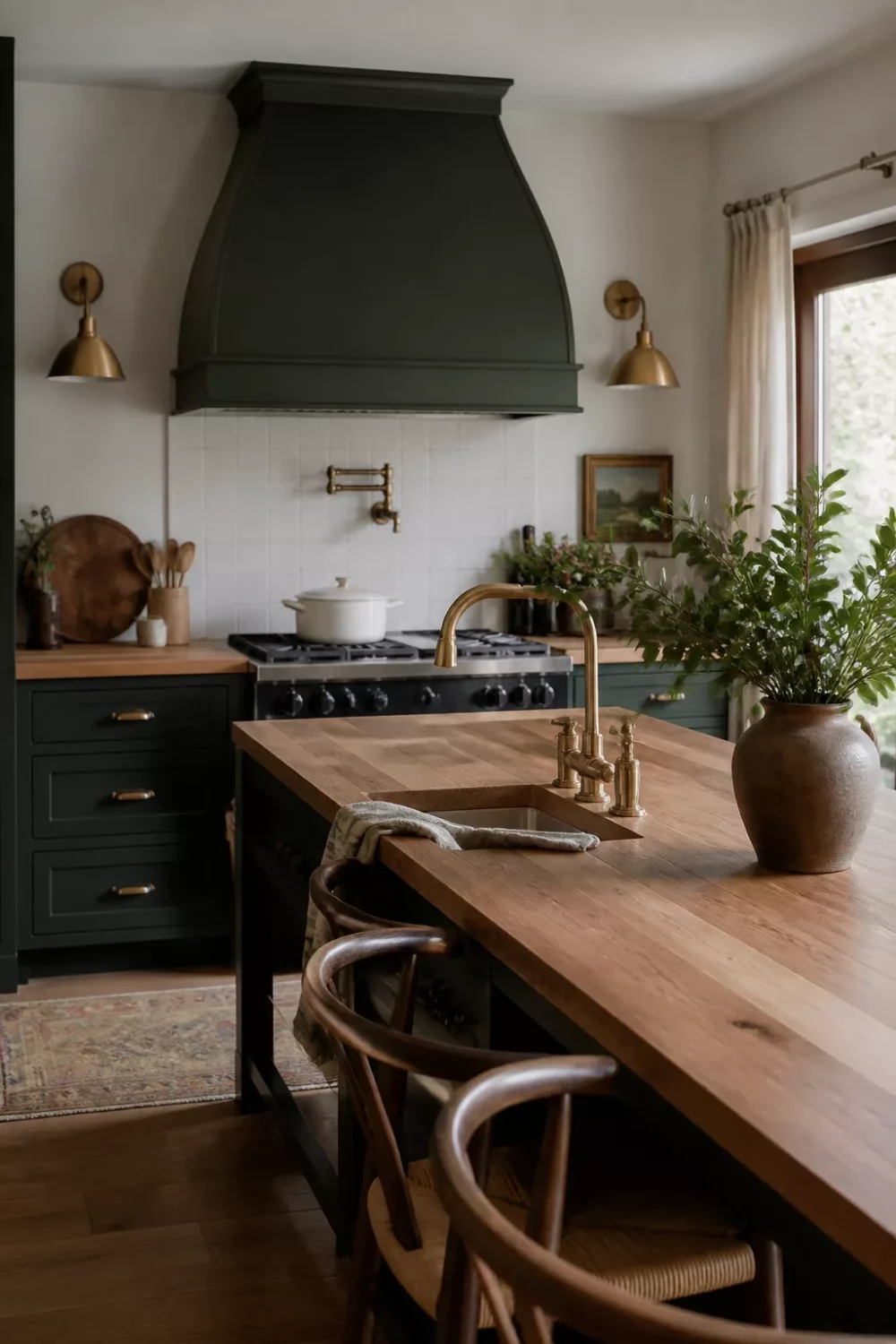 Green kitchen with butcher block countertops featuring deep forest green cabinets and a matching custom range hood